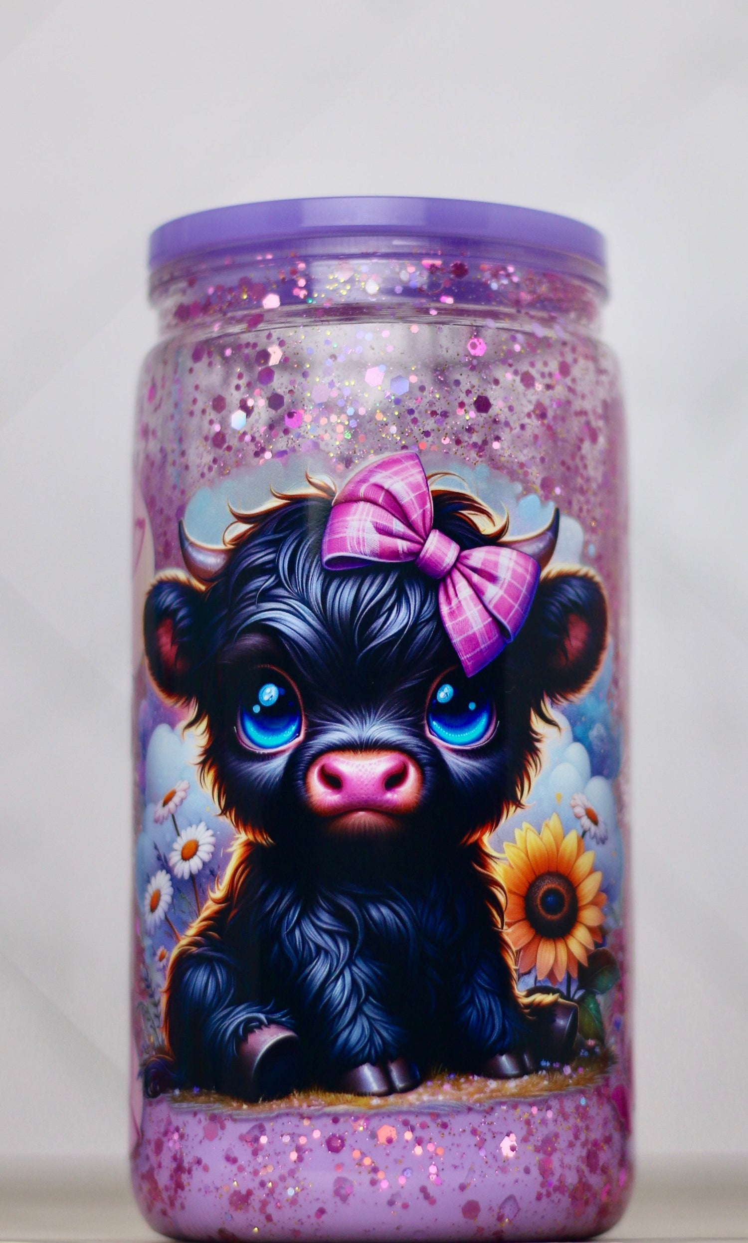 Cute black calf snow globe tumbler with blue eyes, pink bow, and purple glitter